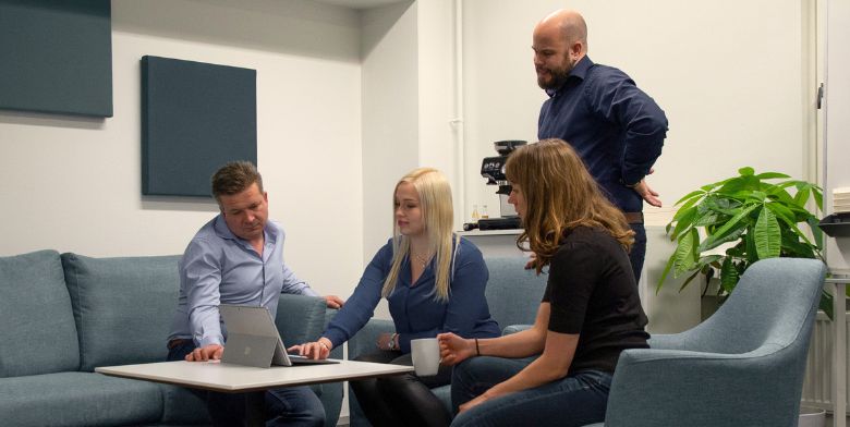 Tre personer som diskuterar vid ett bord med färgprover